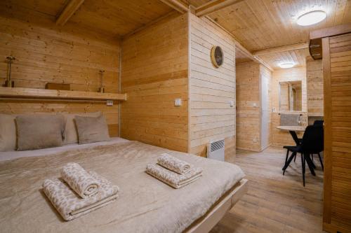 a bedroom with a large bed in a wooden room at Mama Chata a Mama Spa Beskydy in Bílá
