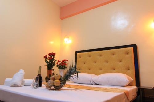 a hotel room with a bed with flowers and wine bottles at RSG Microhotel in General Santos