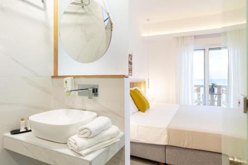 a white bathroom with a sink and a bed at Limenaria Beach in Limenaria