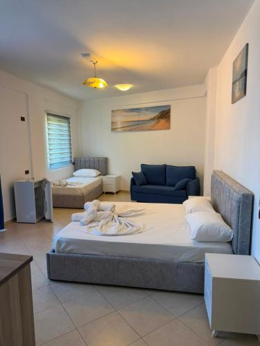 a bedroom with a large bed and a couch at Hotel Klaivi in Lezhë