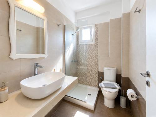 a white bathroom with a sink and a toilet at Eleftheria Hotel & Apartments in Ornos