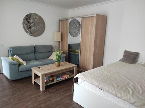 a bedroom with a bed and a couch and a table at Garden Home in Törökbálint
