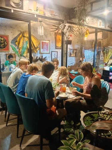 a group of people sitting at a table in a restaurant at Green Valley Lodge in Khao Sok National Park