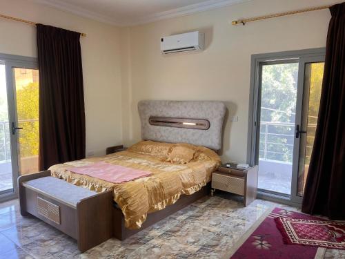 a bedroom with a bed in a room with windows at King mariout villa LA FIESTA in Borg El Arab