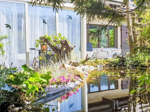 a garden with flowers and plants on a house at Apartment Ferienhüsli by Interhome in Siglistorf