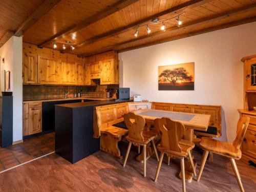 a kitchen with wooden cabinets and a table and chairs at Apartment Wohnung Wettstein by Interhome in Sörenberg