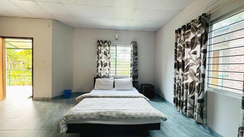 a bedroom with two beds and a window at Neelima Resort in Cox's Bazar
