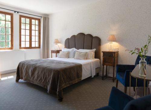 a bedroom with a large bed with a large headboard at Château de Fontager in Serves-sur-Rhône