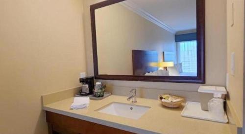 a bathroom with a sink and a large mirror at Huntington Beach Inn in Huntington Beach