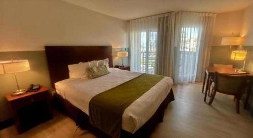 a hotel room with a large bed and a desk at Huntington Beach Inn in Huntington Beach