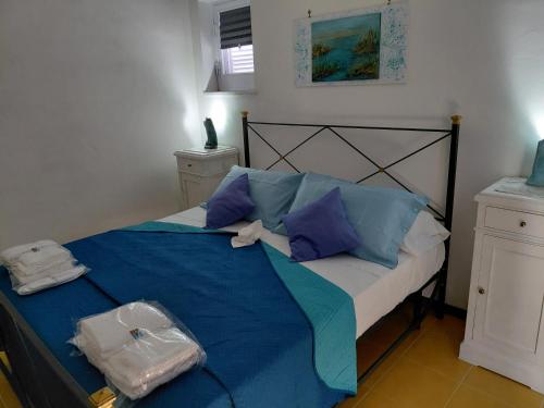a bedroom with a bed with blue sheets and blue pillows at B & B Villa Matisse in Laureana Cilento