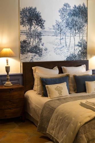 a bedroom with two beds and a painting on the wall at Le Mas de Sòmi in Aubais