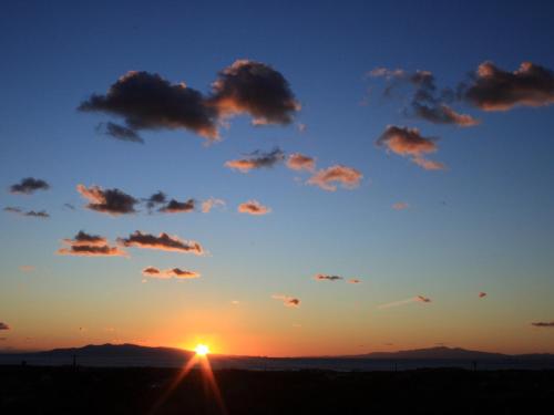 a sunset with clouds in the sky at Hillside Inn Sirocco in Tateyama