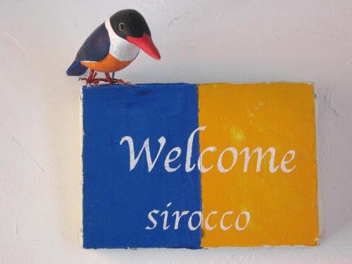 a bird sitting on top of a welcome sign at Hillside Inn Sirocco in Tateyama