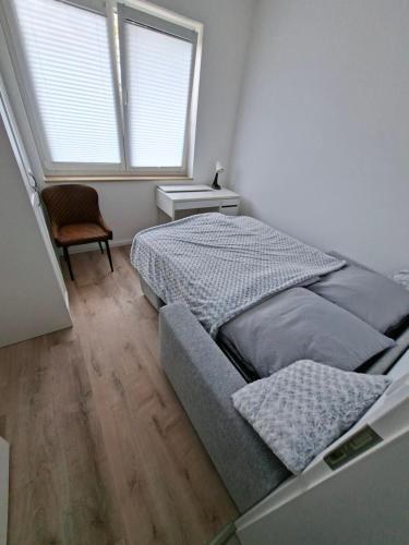 a bedroom with a bed and a chair and a window at Apartment Villa Brieselang in Brieselang