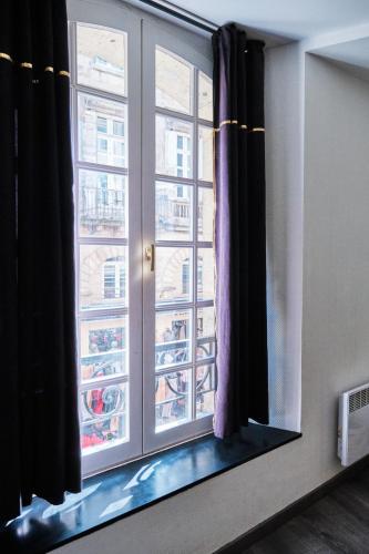 a window with a view of a city at Superbe appartement cosy Centre Bordeaux in Bordeaux