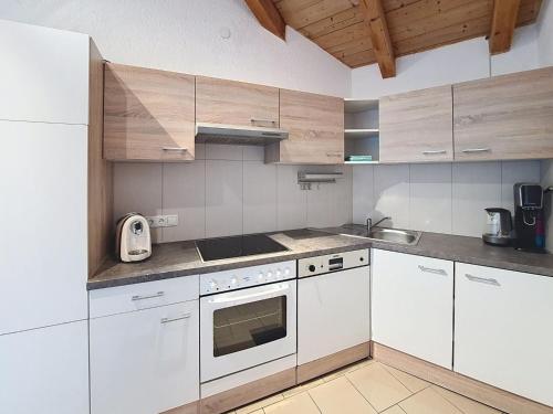 a kitchen with white appliances and wooden cabinets at Apartment Vöstl by Interhome in Navis