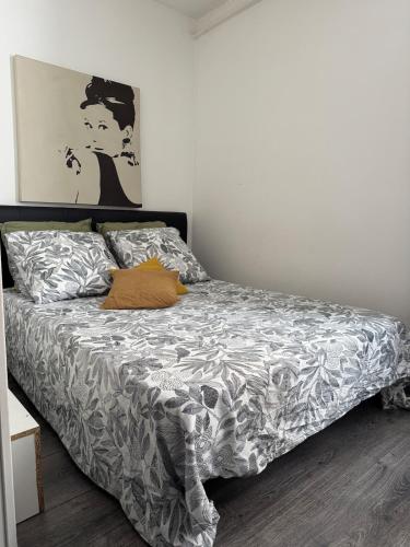 a bedroom with a bed with a gray and white comforter at Superbe appartement cosy Centre Bordeaux in Bordeaux