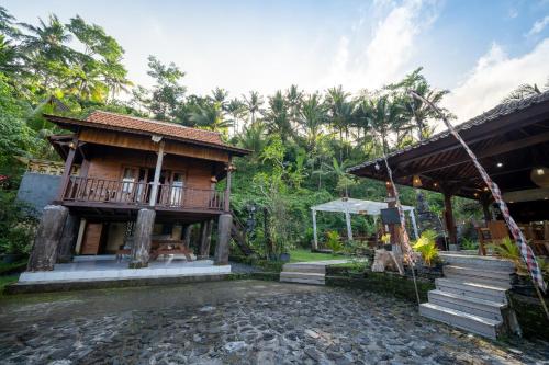 a small house with a balcony and a porch at Medukuh Point Hill in Karangasem
