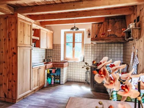 a kitchen with wooden cabinets and a window at by Interhome in Bedollo