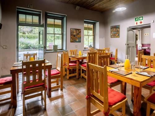 a dining room with wooden tables and chairs at Goedgedacht Farm in Malmesbury
