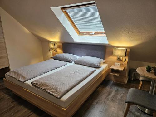 a bedroom with a large bed with a skylight at Pension Villa Strandläufer in Norddeich