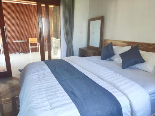 a large bed with blue pillows in a bedroom at MD Amed Guest House in Amed