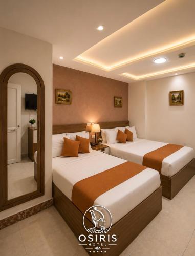 a hotel room with two beds and a mirror at Osiris Hotel Downtown in Cairo