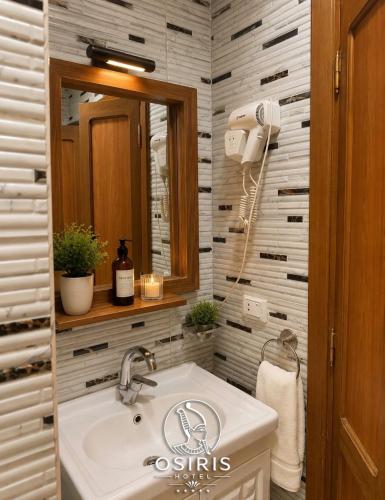 a bathroom with a sink and a mirror at Osiris Hotel Downtown in Cairo