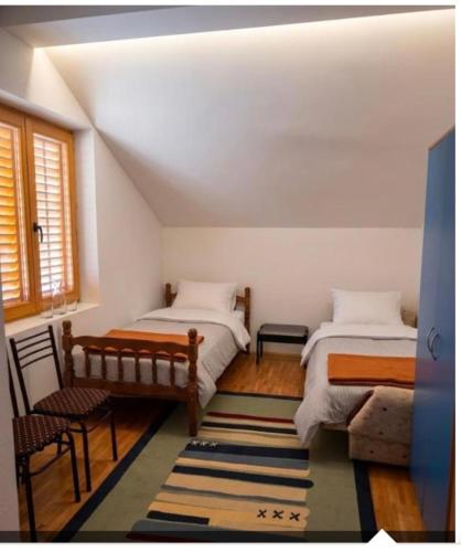 a bedroom with two beds and a bench and a window at Mountain View Retreat near Pelister National Park, Huge Garden, Hiking Paradise in Nižepole