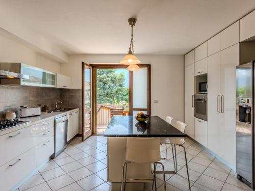 a kitchen with white cabinets and a black counter top at Apartment Legnone by Interhome in Sorico