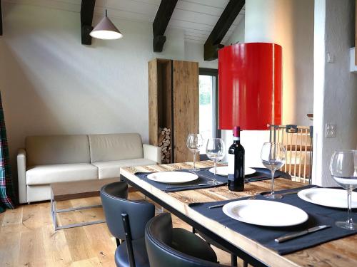 a dining table with wine glasses and a red lamp at Apartment Apt- Terrace by Interhome in Olivone