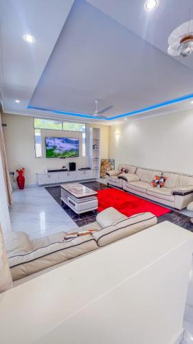 a living room with white couches and a red rug at J&T Holme Villa in Galu