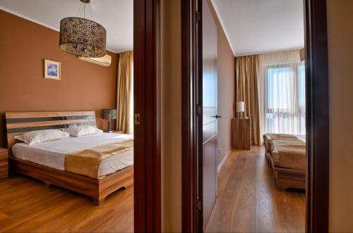 a bedroom with a bed and a couch in it at Apart Hotel Golden Line in Golden Sands