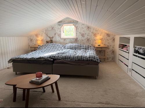 a bedroom with a bed and a table at Skiftehuset in Ytterby
