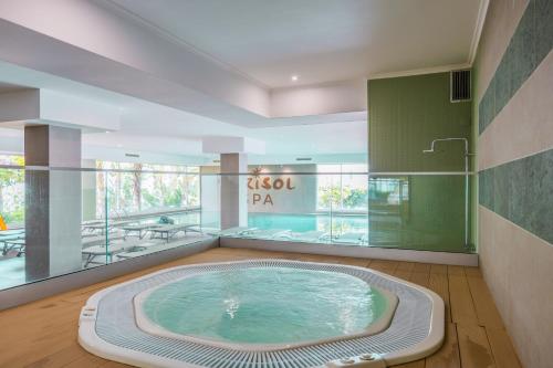 a large swimming pool in a building with a jacuzzi tub at Dorisol Buganvilia Studio Hotel in Funchal