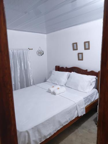 a bedroom with a bed with white sheets and pillows at Apart Cabaña KTIK in San Bernardo del Viento