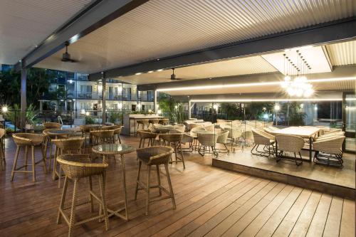 a restaurant with tables and chairs on a deck at Mantra Club Croc in Airlie Beach