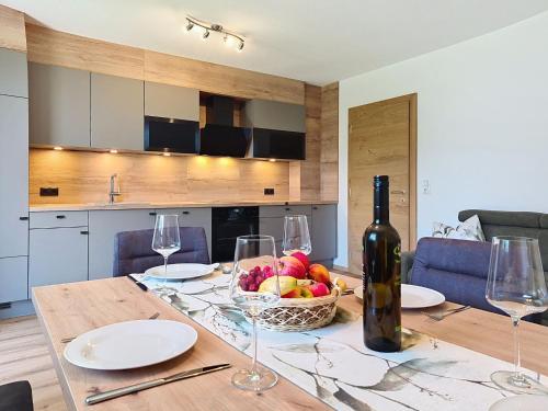 a table with a bowl of fruit and a bottle of wine at Apartment Eben by Interhome in Hippach