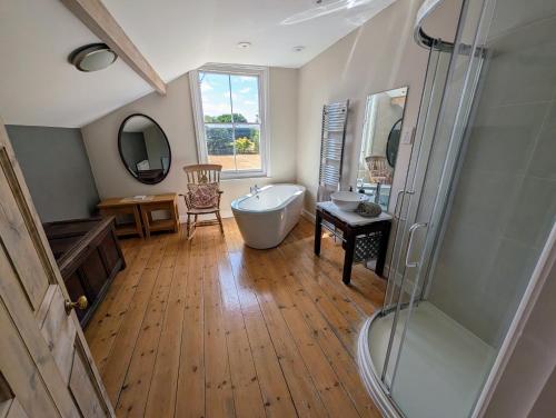 a large bathroom with a tub and a shower at The Lawns House in Holt