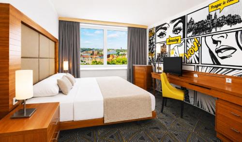 a hotel room with a bed and a desk with a computer at Hotel Uno Prague in Prague