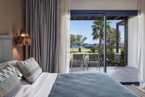 a bedroom with a bed and a view of the ocean at Atlantica Beach Resort Kos in Kardamaina
