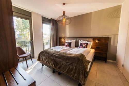 a bedroom with a large bed and a large window at Dormio Resort Maastricht in Maastricht