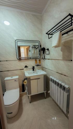 a bathroom with a toilet and a sink and a mirror at Aida hotel PREMIUM in Bukhara