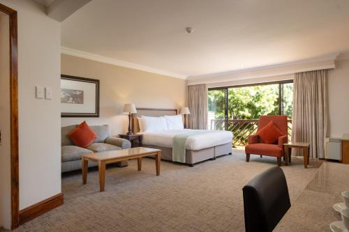 a hotel room with a bed and a couch at Drakensberg Sun Resort in Winterton