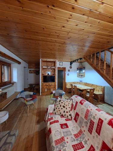 a living room with a couch and a wooden ceiling at Baita degli Alpini in Terminillo