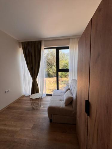 a living room with a couch and a large window at Pollux Astra Bay in Lepetani