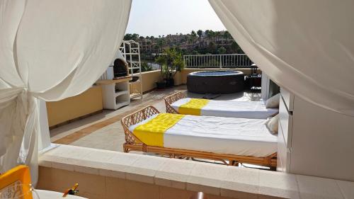 a balcony with two beds on a roof at Tango Andaluz - Sunset Ritual Incl in Fuengirola