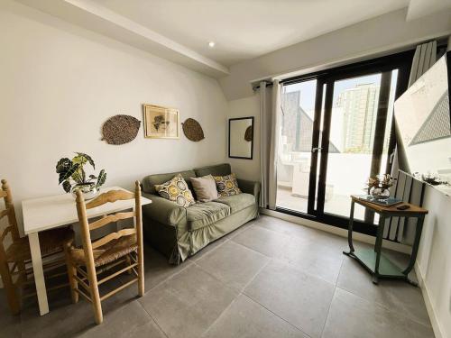 a living room with a couch and a table at Luxury beach penthouse with Jacuzzi in Fuengirola