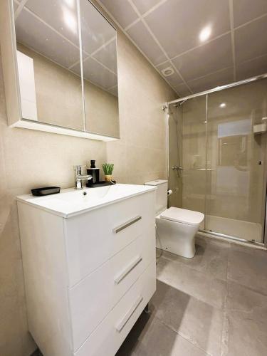 a white bathroom with a sink and a toilet at Luxury beach penthouse with Jacuzzi in Fuengirola